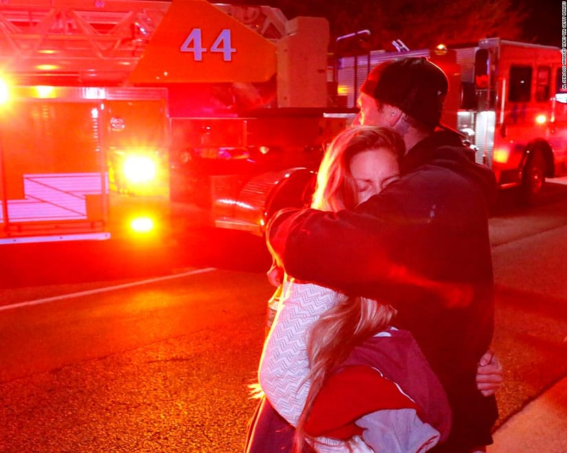 THOUSAND OAKS, CA - NOVEMBER 08: Molly Esterline is hugged by David Crawford on scene after a shooter wounded seven Wednesday night on November 8, 2018 in Thousand Oaks, California. The gunman burst into the bar around 11:20 p.m., cloaked in all black as he threw smoke bombs and began shooting at targets as young as 18 inside the Borderline Bar