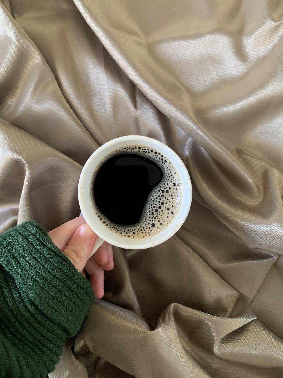 person holding white ceramic mug with coffee